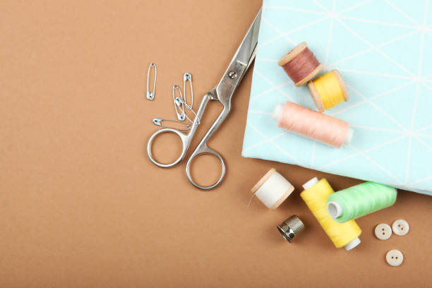 istock different sewing accessories on the table. Threads, needles, pins, fabric and sewing scissors close up 1270188873