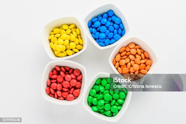 Five Squared Bowls With Small Red Yellow Blue Green And Orange Coated Chocolate Candies Similar To Mms In A Squared Bowl Isolated On White Background Top View Stock Photo - Download Image Now