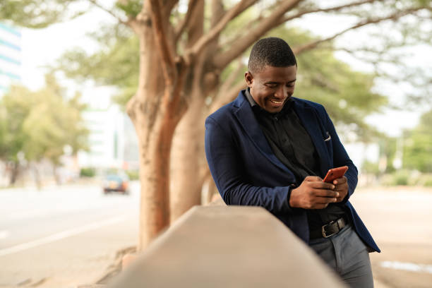 istock Black Man Smiling and Texting on His Phone 1270195575