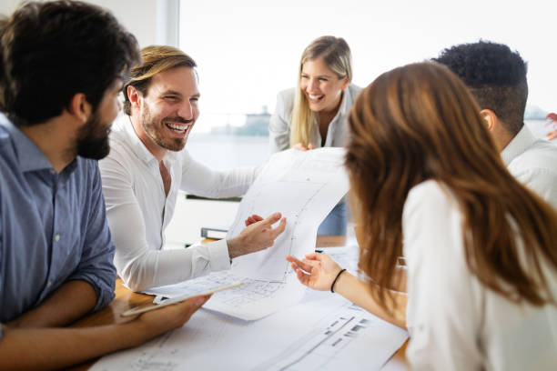istock Team of architects working on construction plans in office 1270195916