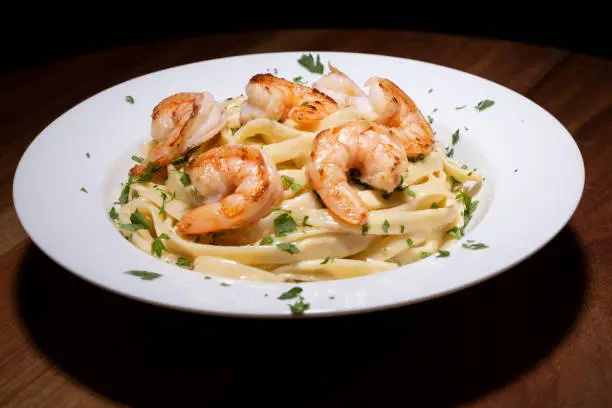 saucer detail with spaghetti and shrimp. gourmet food