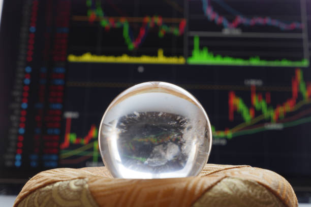 Predict the future with crystal balls and stock charts projected on a laptop