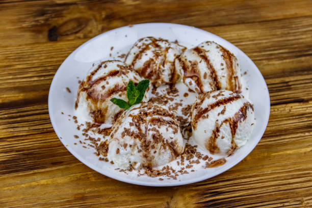 istock Vanilla ice cream with chocolate topping in white plate on a wooden table 1270203075