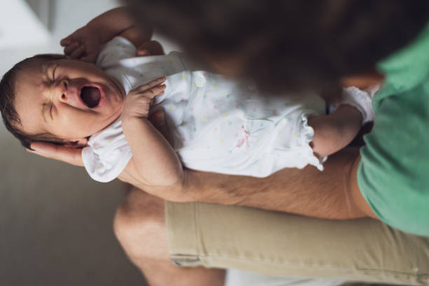 istock Newborn baby yawning in father's hands 1270204843