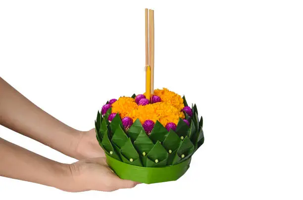 Photo of Hand holding Banana leaf Krathong for Thailand full moon or Loy Krathong festival.