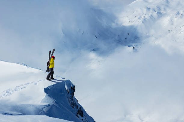 남자는 상단에 스키 스탠드와 눈 산에 동의 - cliff mountain winter snow 뉴스 사진 이미지
