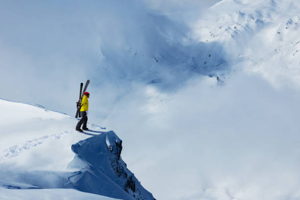 Man to concur snow mountain with ski stand on top