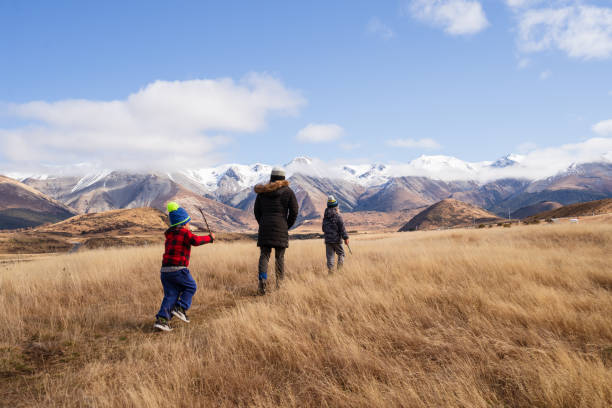 Young woman tourist with son looking at the mountains, back view