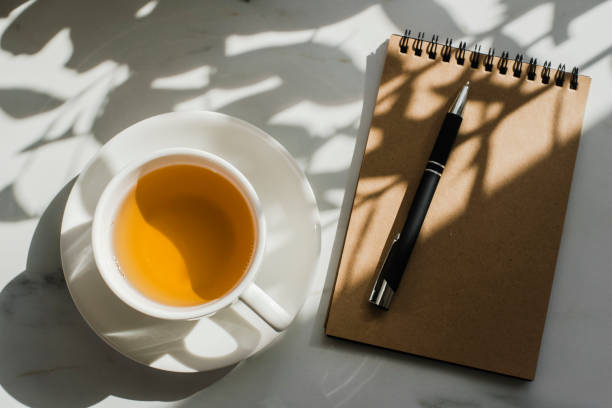 istock Cup of herbal green tea at marble table with notebook 1270211042