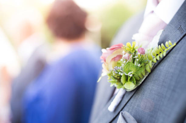 Small wedding bouquet on groom's tuxedo Small wedding bouquet on groom's tuxedo. Closeup photo dinner jacket stock pictures, royalty-free photos & images