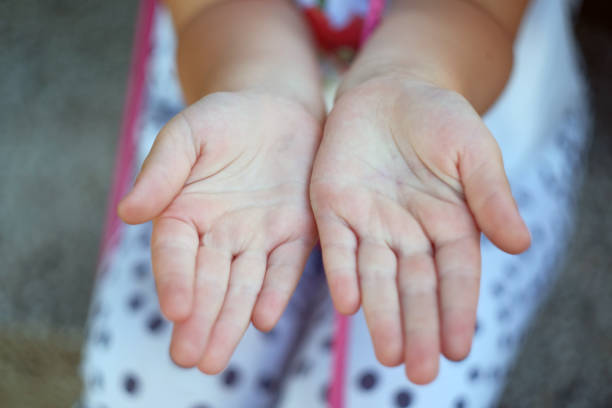 A hand of a girl touches a blossom bud