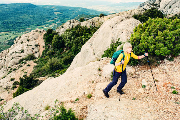 Mont Sainte Victoire hiking trail, Provence, France Senior woman hiking on a footpath on Mont Sainte Victoire, Provence, France. Classic hiking circuit via ascent of the Pas du Clapier, the Croix, and the descent of the Pas du Berger. montagne sainte victoire stock pictures, royalty-free photos & images