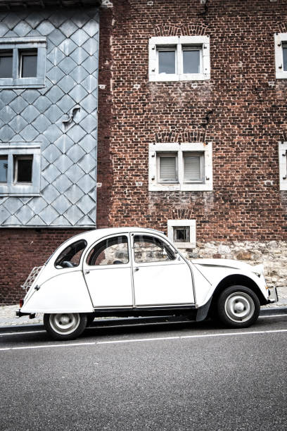 классический французский citroen 2cv автомобиль, припаркованный на обочине улицы - citroën 2cv стоковые фото и изображения