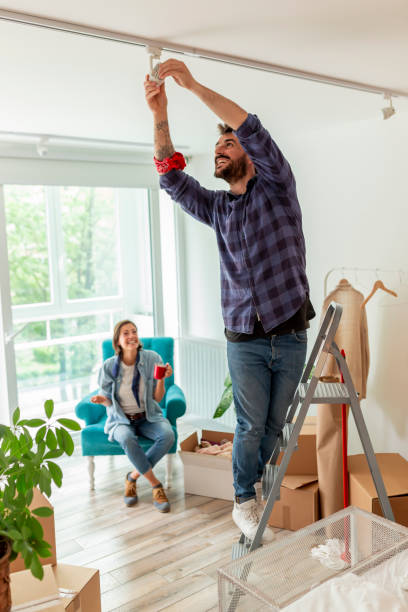 istock Couple redecorating apartment, man changing light bulb 1270218293