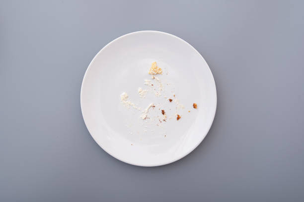 White plate with crumbs and cream after sweet cake, top view White plate with crumbs and cream after sweet cake, top view empty plate stock pictures, royalty-free photos & images