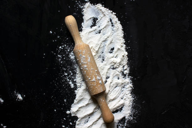istock Rolling pin for rolling dough on a floured black surface. Located in the center. The view from the top. Baking. Homemade food. Copy space for text 1270220516