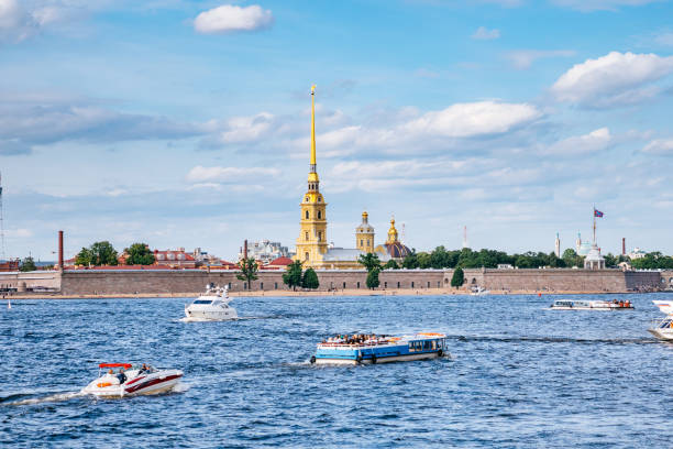 View of the Peter and Paul Fortress in Saint Petersburg through Neva River. Saint Petersburg skyline - Peter and Paul Fortress on the blue and cloudy sky background. peter and paul cathedral st petersburg stock pictures, royalty-free photos & images