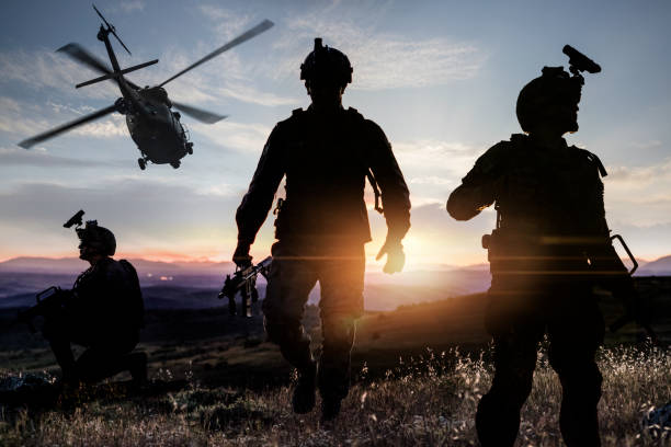 Silhouettes of soldiers during Military Mission  at Sunset Silhouettes of soldiers during Military Mission  at Sunset infantry stock pictures, royalty-free photos & images