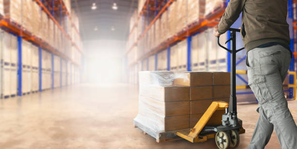 istock Shipment boxes, Cargo warehouse. Worker with hand pallet truck unloading pallet goods in a large warehouse storage. 1270224770