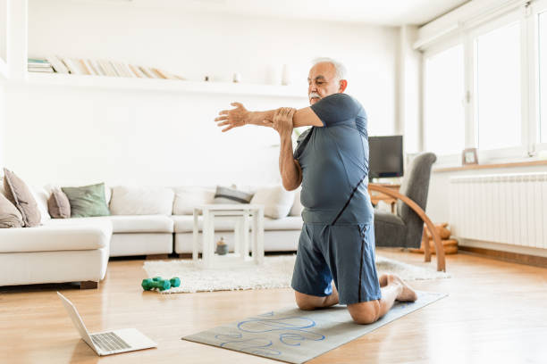 istock Active senior man home exercising with online coach 1270225678