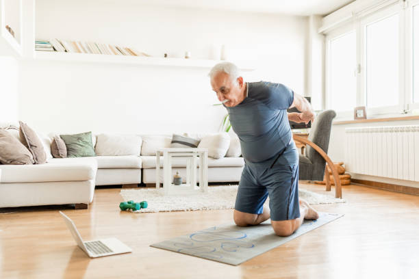 istock Active senior man home exercising with online coach 1270225686
