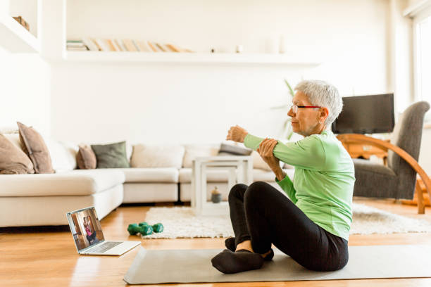 istock Active senior woman home exercising with online coach 1270225703