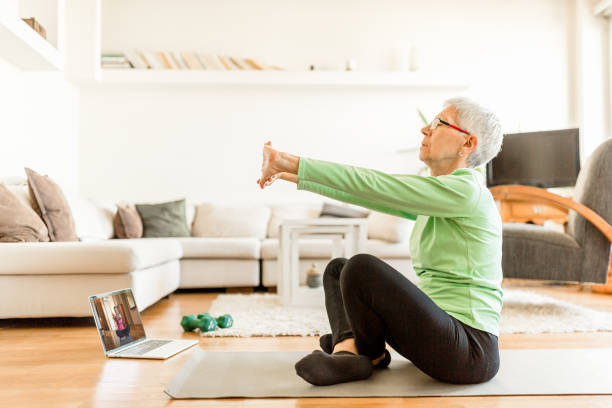 istock Active senior woman home exercising with online coach 1270225724