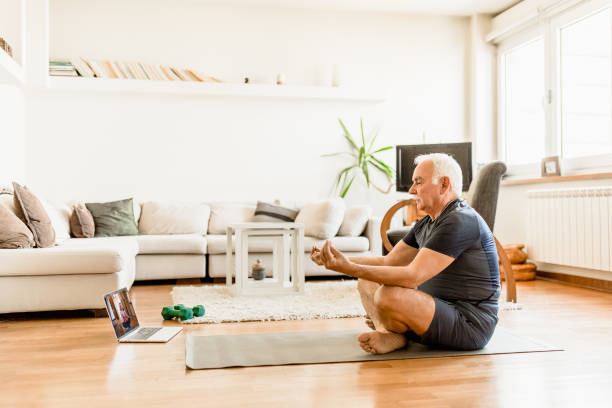 istock Active senior man home exercising with online coach 1270225740
