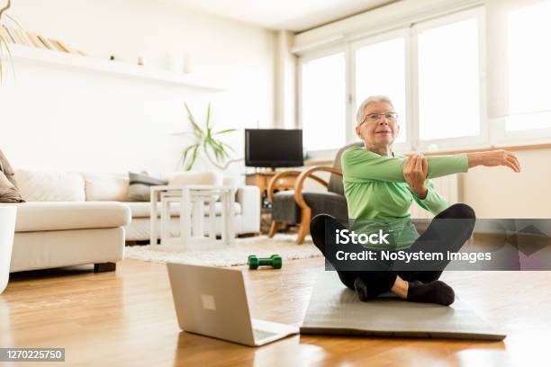 Active Senior Woman Home Exercising With Online Coach Stock Photo - Download Image Now