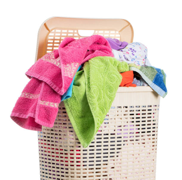 istock Laundry basket full of dirty washing (isolated on white) 1270227111