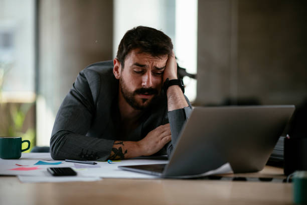istock Tired businessman working with laptop at office. 1270228492