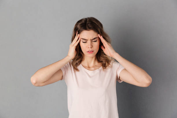 istock Confused woman in t-shirt having headache while holding head 1270228549