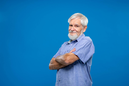 Portrait of happy casual mature man smiling, senior age man with gray hair, Isolated on gray background, copy space