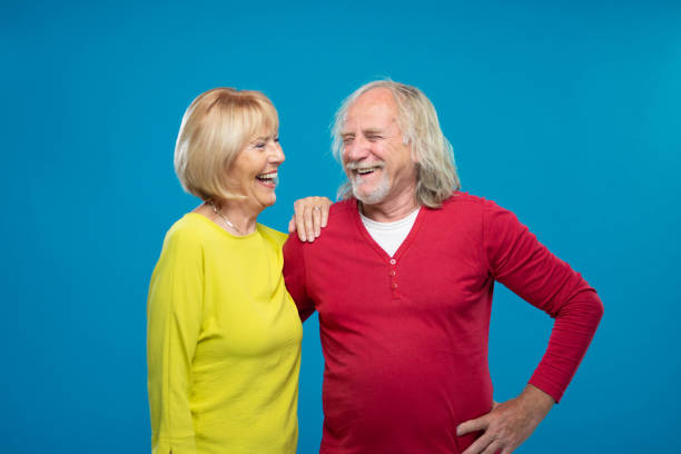 istock Senior Couple Laughing On Blue Background 1270233196