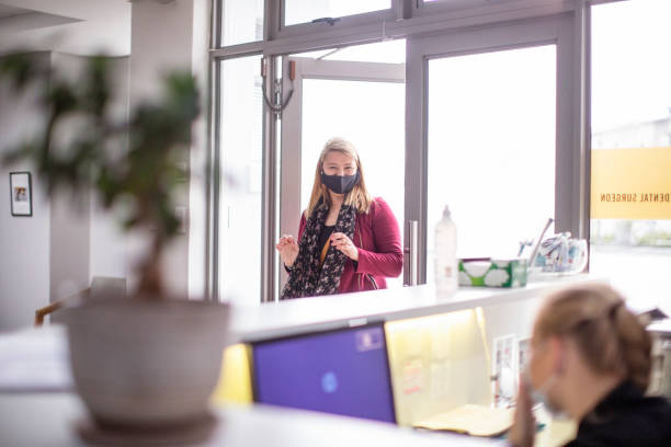 une femme arrive pour un rendez-vous chez le dentiste. - dentist surgery dental hygiene using voice photos et images de collection