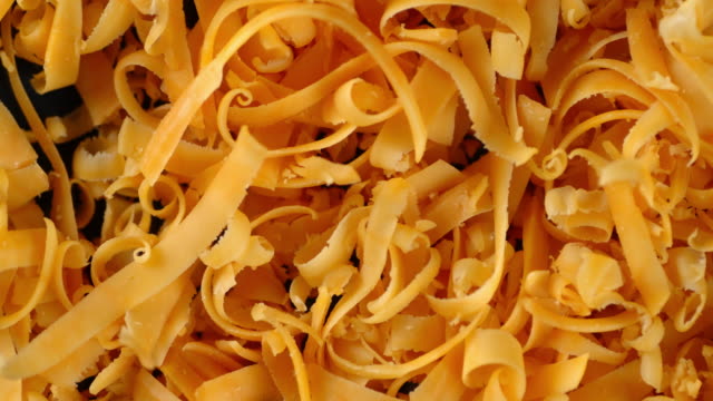 Grated cheddar cheese slowly rotates.