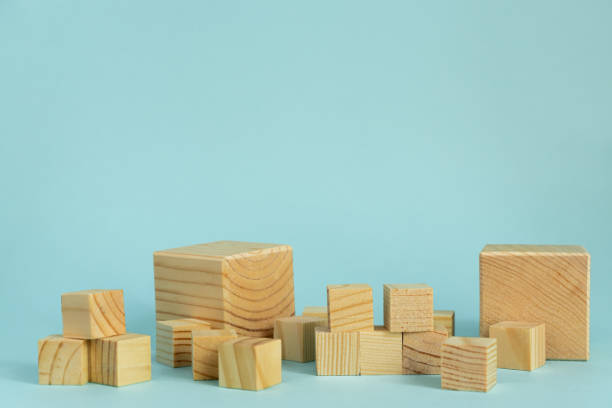 istock Construction of wooden cubes on blue background with copy space. Mockup composition for design. 1270238989