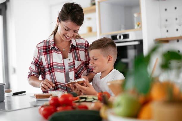 istock Mother and son eating sandwich in kitchen. 1270243987