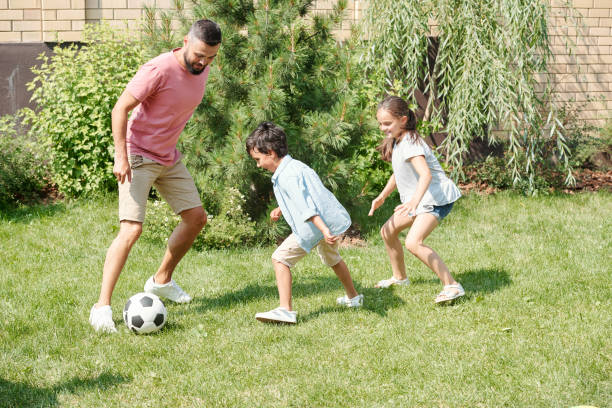istock Father Playing Footaball With Children 1270244101