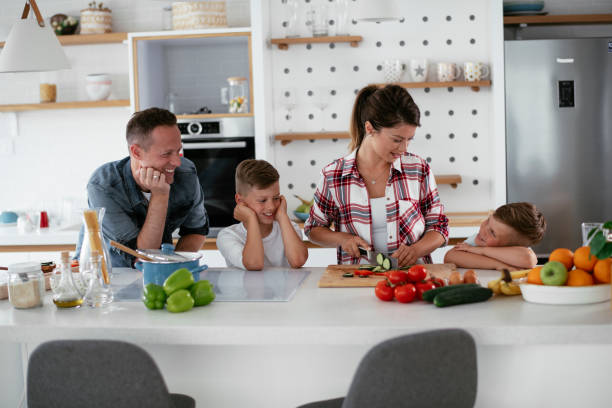 istock Mother and father making breakfast with sons. 1270244898
