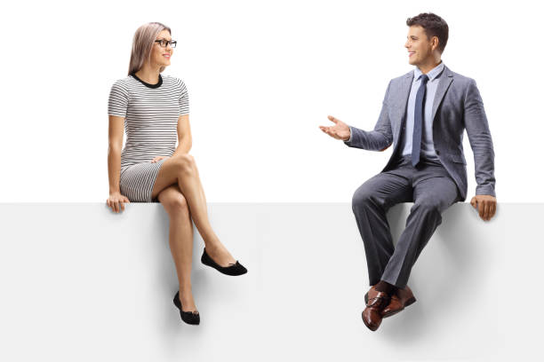 istock Man and woman sitting on a white banner and having a conversation 1270245801