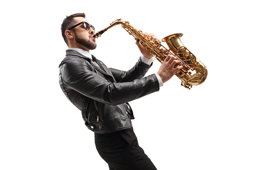 Side shot of male musician in a leather jacket playing a saxophone isolated on white background