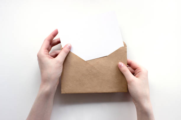 istock Envelope and white empty letter mock-up in female hands top view. Communication, information, post, mail concept. Web, social media banner template. Stock photo. 1270247699