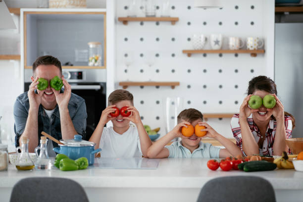 istock Mother and father making breakfast with sons. 1270248005