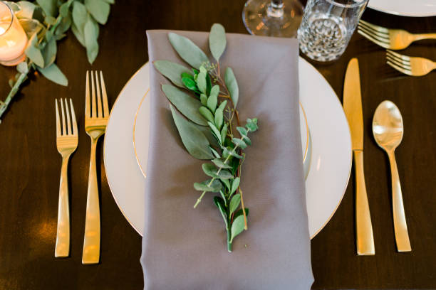 istock A beautiful table setting with a white plate, gray napkins, and gold silverware. 1270248880