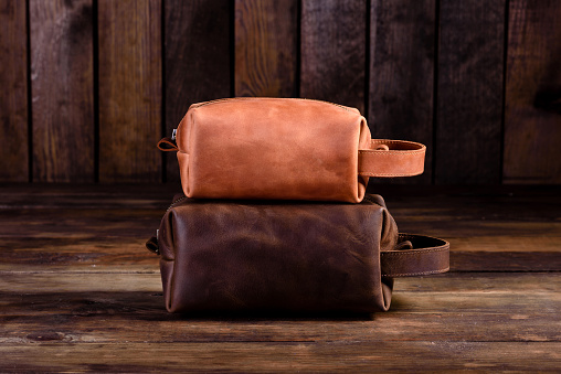 Old vintage leather bag with leather strap. Beautiful small women's leather bag on a wooden background