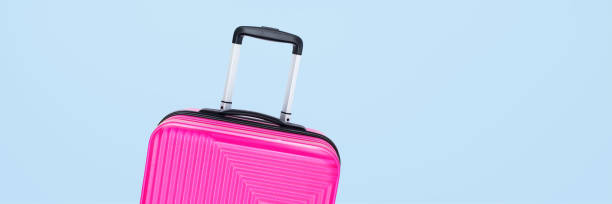 istock banner pink suitcase isolated on blue background 1270249603