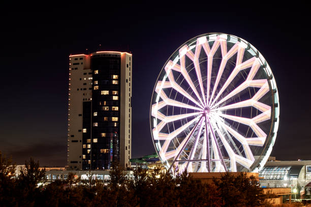 istock Silhouette building, ferris wheel bright lights night 1270250784