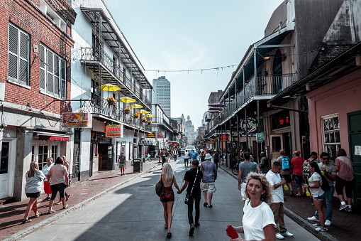 People walk on colorful Bourbon Street in the French Quarter of New Orleans, Louisiana.