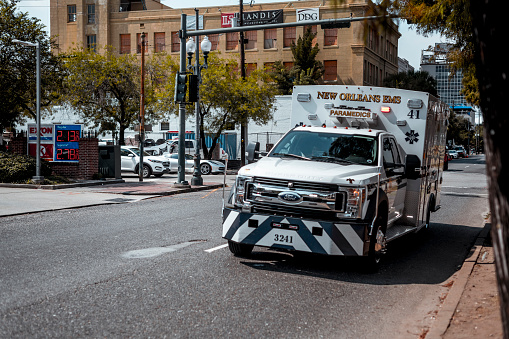 The ambulance (emergency) car cross the intersection of Howard Ave. and Carondelet St. in New Orleans, Louisiana.